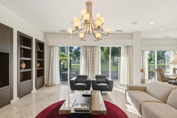 a living room with furniture a chandelier and a fireplace