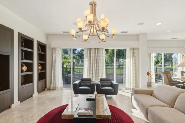 a living room with furniture a chandelier and a fireplace