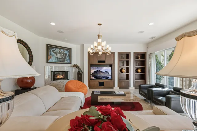 a living room with furniture a chandelier and a dining table