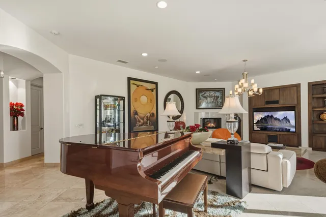 a dining room with furniture a chandelier and a floor to ceiling window