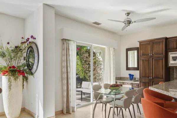 a living room with furniture kitchen view and large windows
