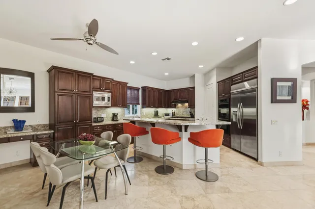 a kitchen with stainless steel appliances granite countertop a refrigerator and a sink