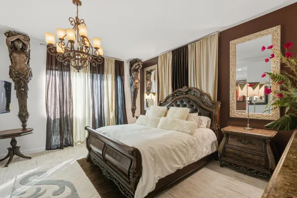 a bedroom with a bed and a chandelier