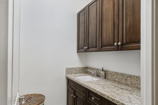 a view of a house with palm trees and a small yard