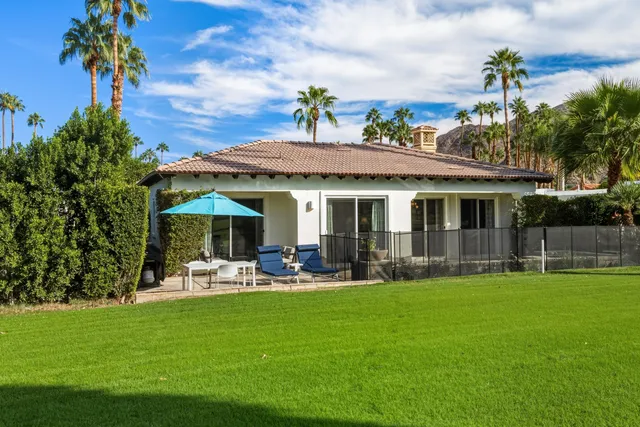 a patio with a table and chairs under an umbrella