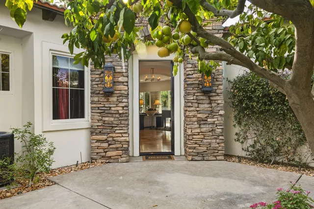 front view of a brick house with a large tree