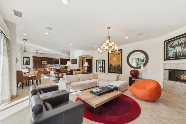 a living room with furniture chandelier and a large window