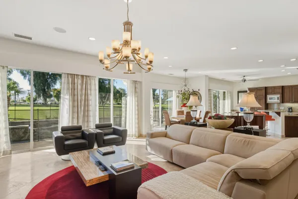 a living room with furniture a fireplace and a chandelier
