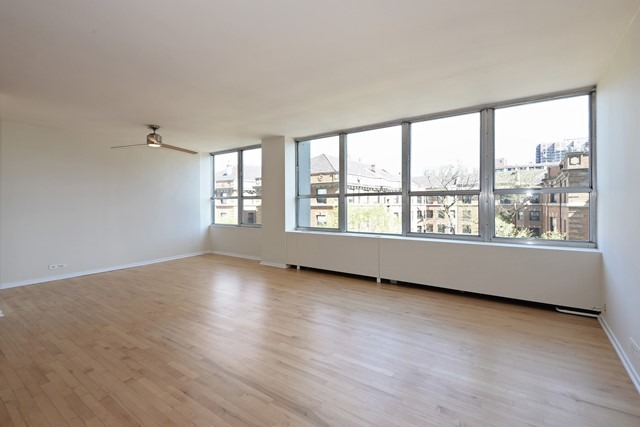 655 West Irving Park Road, Unit 312 Chicago, IL 60613 - Photo 3 of 10 an empty room with wooden floor and windows