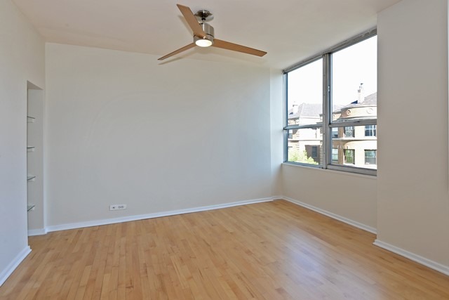 655 West Irving Park Road, Unit 312 Chicago, IL 60613 - Photo 6 of 10 wooden floor in an empty room with a window