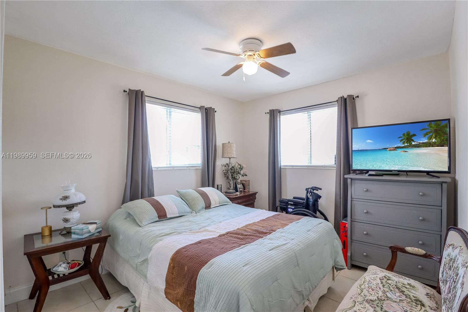 10941 Southwest 180th Street Miami, FL 33157 - Photo 16 of 29 a bedroom with a bed and a chandelier