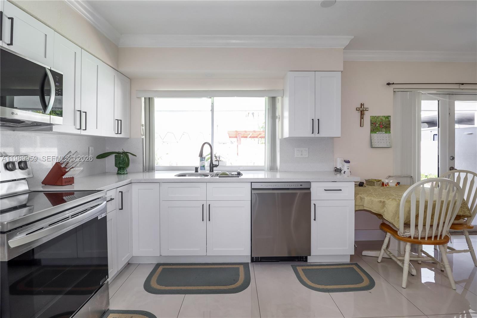 10941 Southwest 180th Street Miami, FL 33157 - Photo 6 of 29 a kitchen with sink cabinets and window