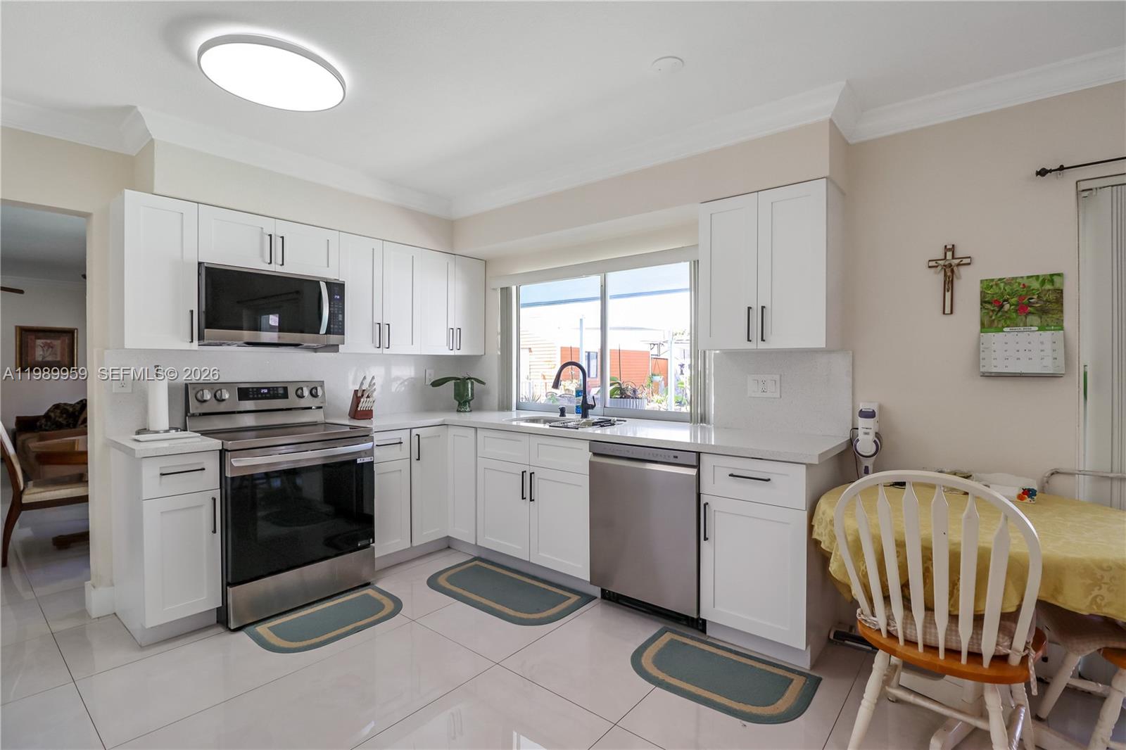 10941 Southwest 180th Street Miami, FL 33157 - Photo 7 of 29 a kitchen with a stove a sink and a microwave