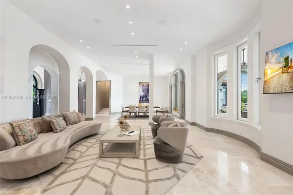 a large white kitchen with kitchen island a sink a stove a dining table and chairs