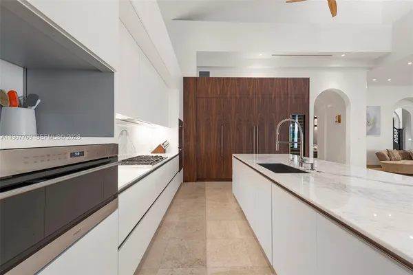 a living room with furniture and a refrigerator