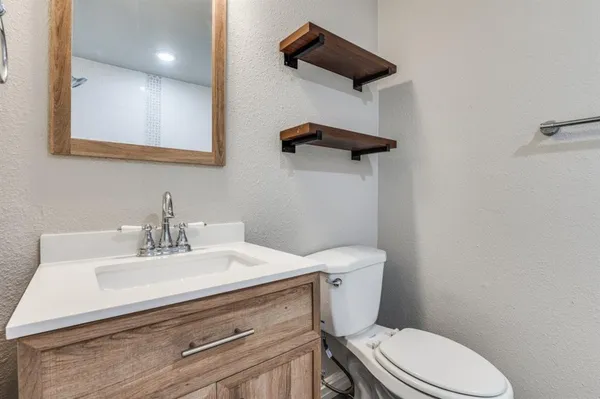 a bathroom with a sink a toilet and mirror