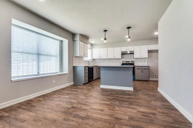 a view of kitchen with granite countertop cabinets and wooden floor
