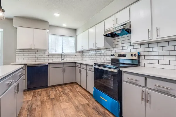 a kitchen with stainless steel appliances granite countertop a sink stove and cabinets