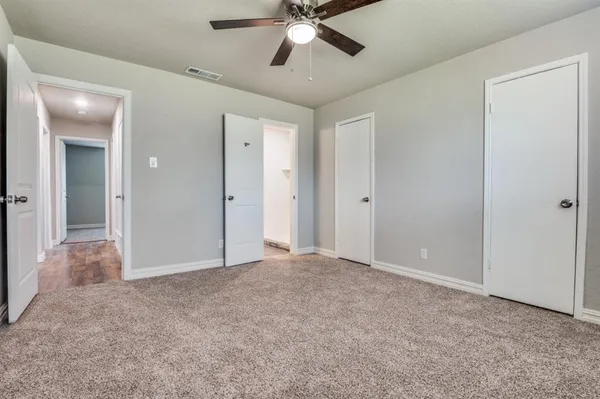 an empty room with fan and entrance
