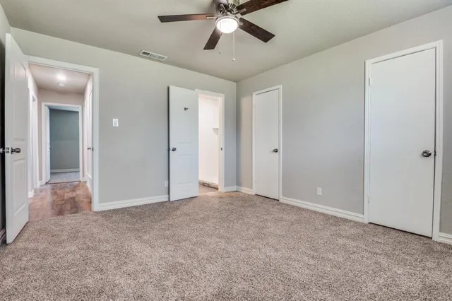 an empty room with fan and entrance