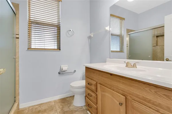 a bathroom with a granite countertop toilet a sink and a mirror