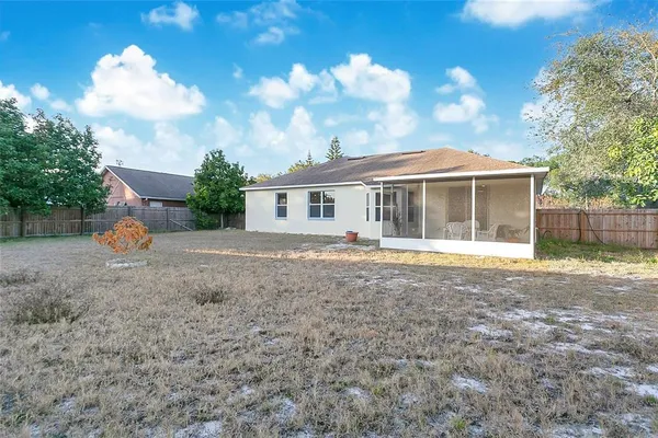 a view of a house with a backyard and a tree