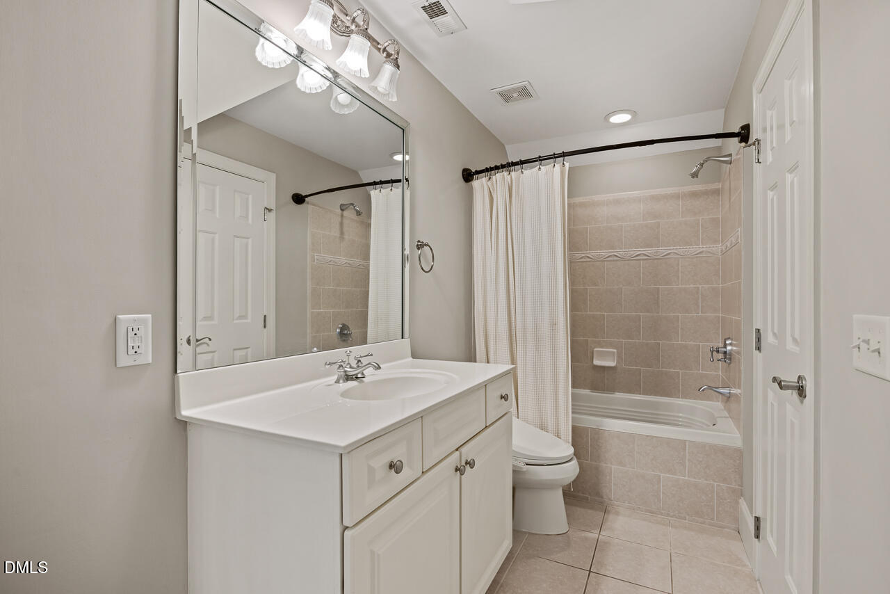 4004 Frontenac Court Apex, NC 27539 - Photo 34 of 61 a bathroom with a shower sink vanity mirror and toilet