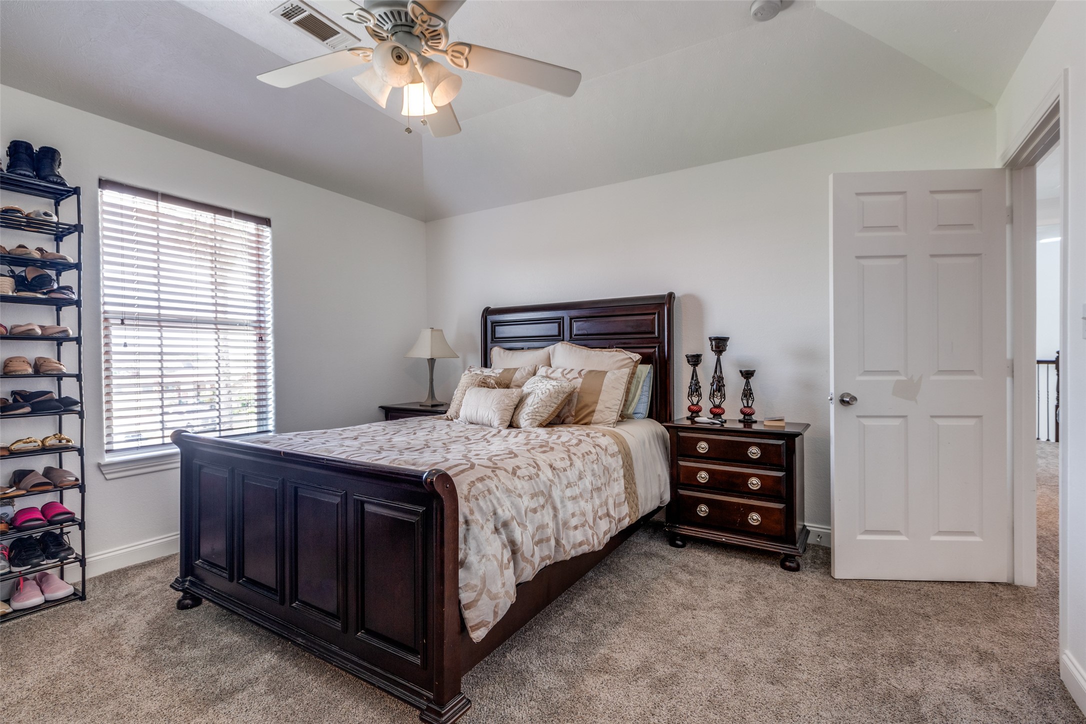 8 Cypress Point Court Manvel, TX 77578 - Photo 13 of 18 a bed sitting in a bedroom next to a window and a chandelier