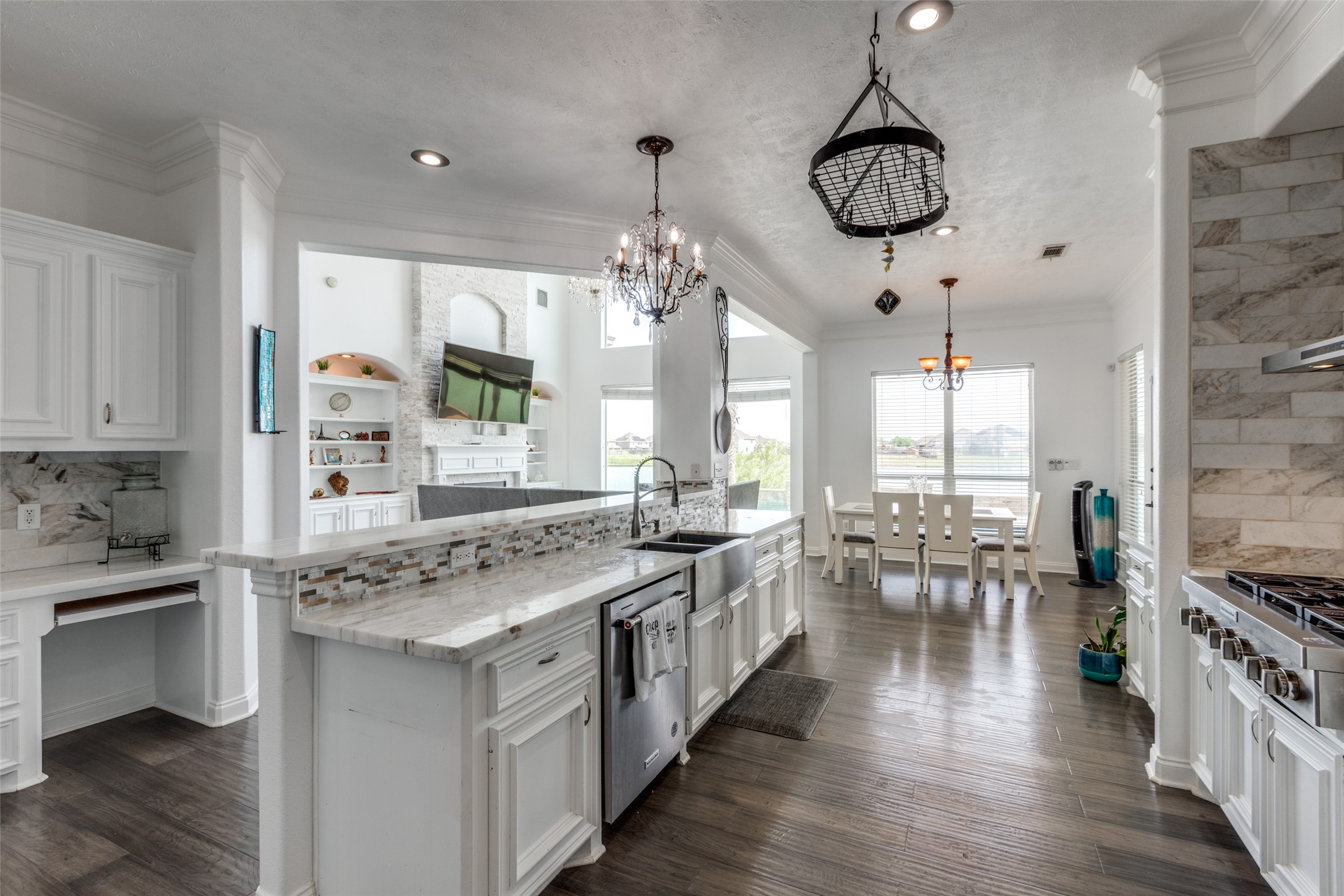 8 Cypress Point Court Manvel, TX 77578 - Photo 5 of 18 a kitchen with stainless steel appliances a stove a sink dishwasher a dining table and chairs with wooden floor