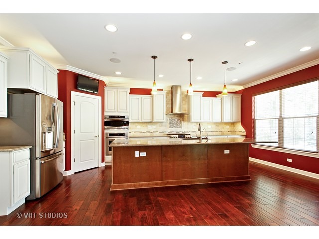 287 Hickory Road Lake Zurich, IL 60047 - Photo 2 of 25 a kitchen with stainless steel appliances granite countertop a refrigerator a sink dishwasher a stove and white countertops with wooden floor
