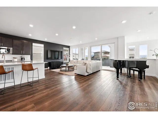 a living room with furniture and a dining table with kitchen view