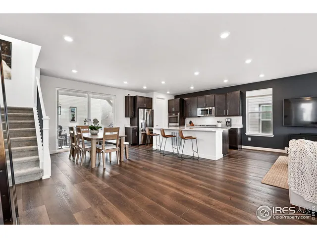 a living room with furniture and kitchen view with wooden floor