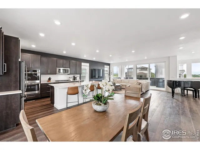a kitchen with a table chairs a refrigerator and a dining table