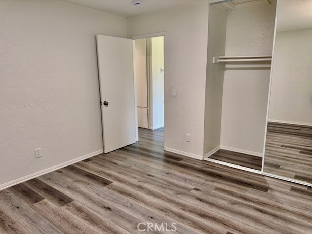 73740 Santa Rosa Way, Unit E Palm Desert, CA 92260 - Photo 7 of 15 a view of an empty room with wooden floor and a window