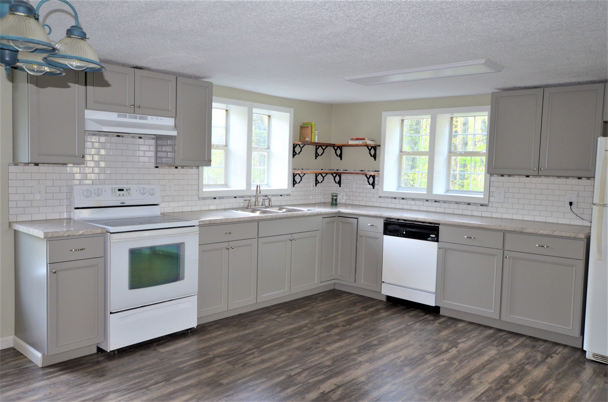 a kitchen with a sink cabinets wooden floor and view living room