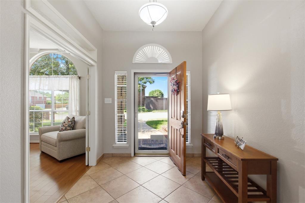 4218 Glistening Spring Rowlett, TX 75088 - Photo 5 of 39 Entryway featuring diamond-patterned tile flooring, a paneled wood-finish door with sidelights, and a transom window