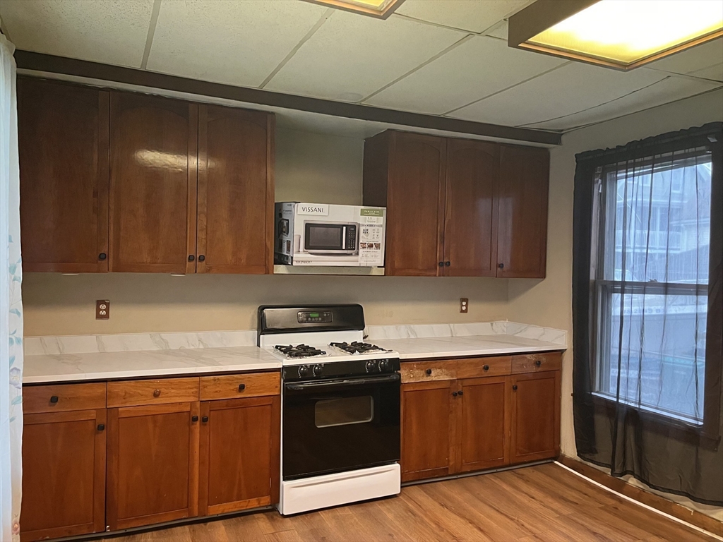 6 Minot Street, Unit 6 Lynn, MA 01905 - Photo 4 of 10 a kitchen with stainless steel appliances granite countertop a stove a sink and a microwave