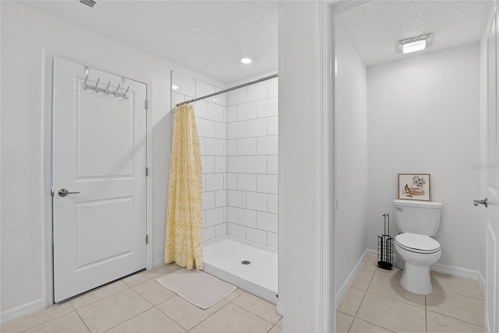 13084 Garnet Raspberry Avenue Wimauma, FL 33598 - Photo 12 of 20 a bathroom with a shower and a toilet