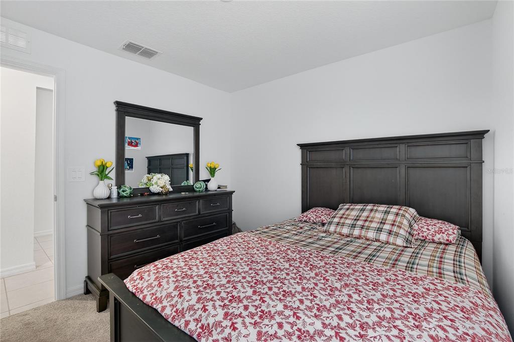 13084 Garnet Raspberry Avenue Wimauma, FL 33598 - Photo 13 of 20 a bedroom with a bed and a dresser in it