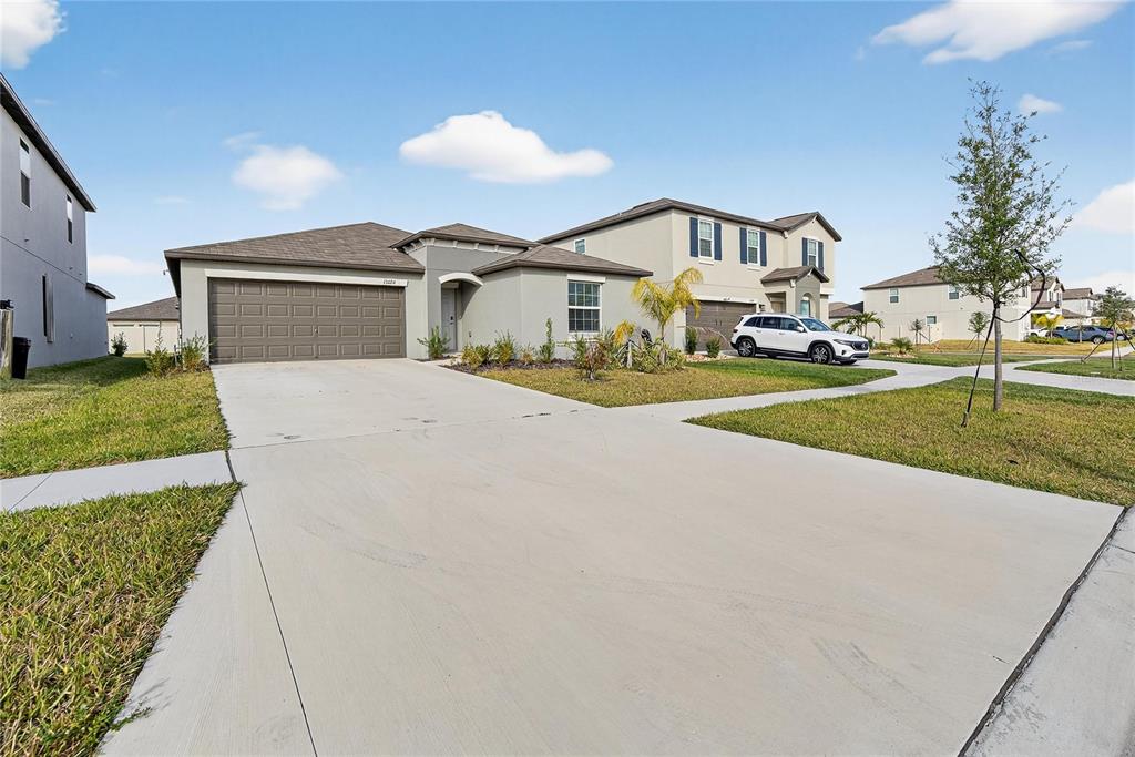 13084 Garnet Raspberry Avenue Wimauma, FL 33598 - Photo 20 of 20 a front view of a house with a yard and garage