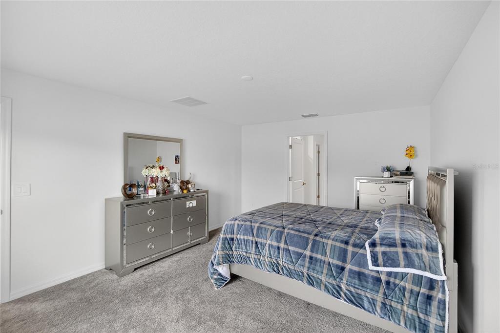 13084 Garnet Raspberry Avenue Wimauma, FL 33598 - Photo 9 of 20 a bedroom with a bed and a dresser in it