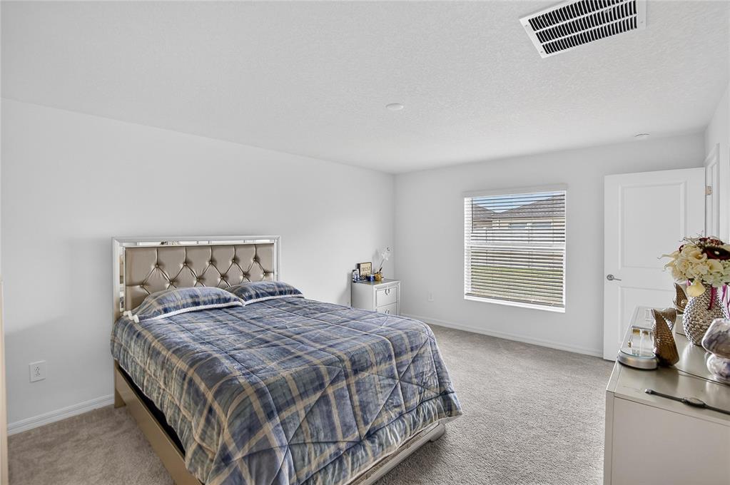 13084 Garnet Raspberry Avenue Wimauma, FL 33598 - Photo 10 of 20 a bedroom with a bed and a chair