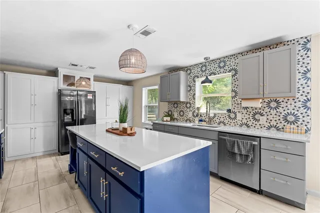 a kitchen with stainless steel appliances granite countertop a sink and a stove