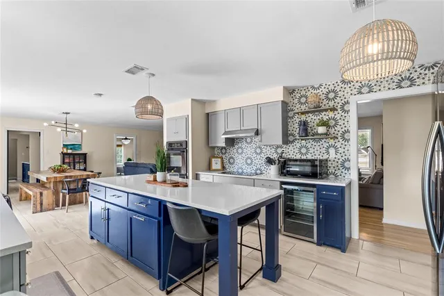 a kitchen with stainless steel appliances granite countertop a stove a sink dishwasher and a refrigerator with wooden floor