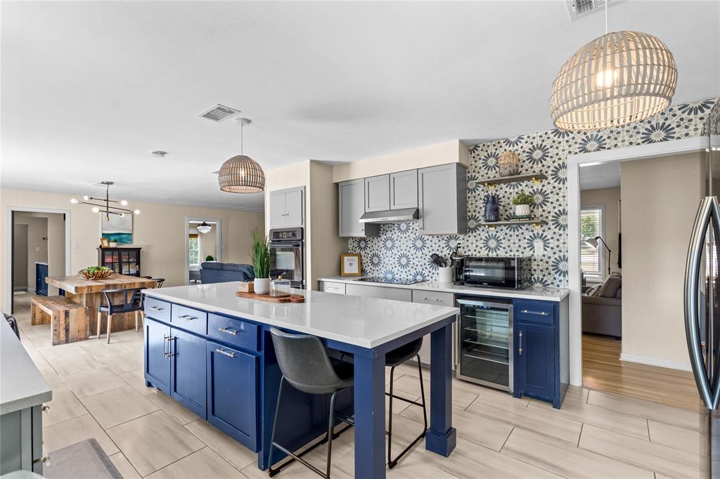 1933 Walter Smith Road Azle, TX 76020 - Photo 17 of 40 a kitchen with stainless steel appliances granite countertop a stove a sink dishwasher and a refrigerator with wooden floor