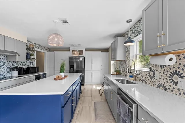 a kitchen with stainless steel appliances kitchen island granite countertop a sink and cabinets