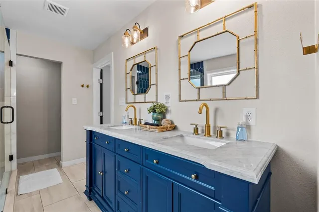 a bathroom with a granite countertop double vanity sink and a mirror