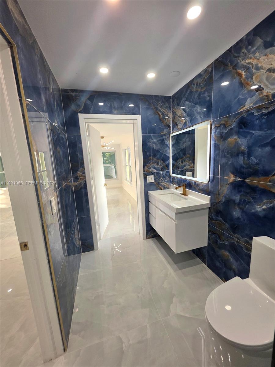 Davie Davie, FL 33314 - Photo 16 of 44 a bathroom with a sink and mirror with toilet