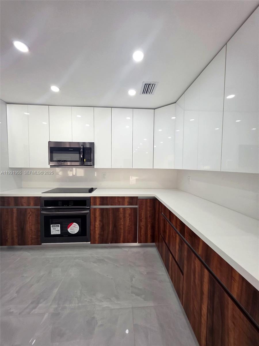 Davie Davie, FL 33314 - Photo 2 of 44 a kitchen with stainless steel appliances granite countertop a stove a sink and a microwave