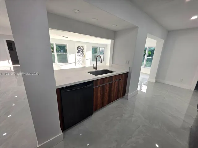 a kitchen with a sink a window and cabinets